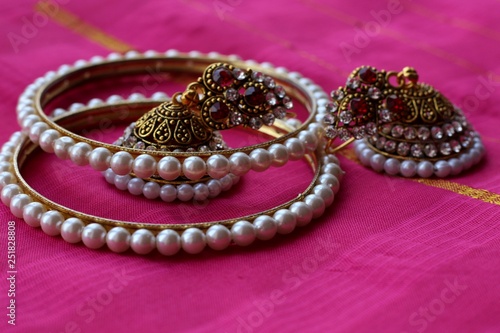 Indian decorations for dancing: bracelets, earrings for dancing bharatanatyam or kathak. Fabric background.