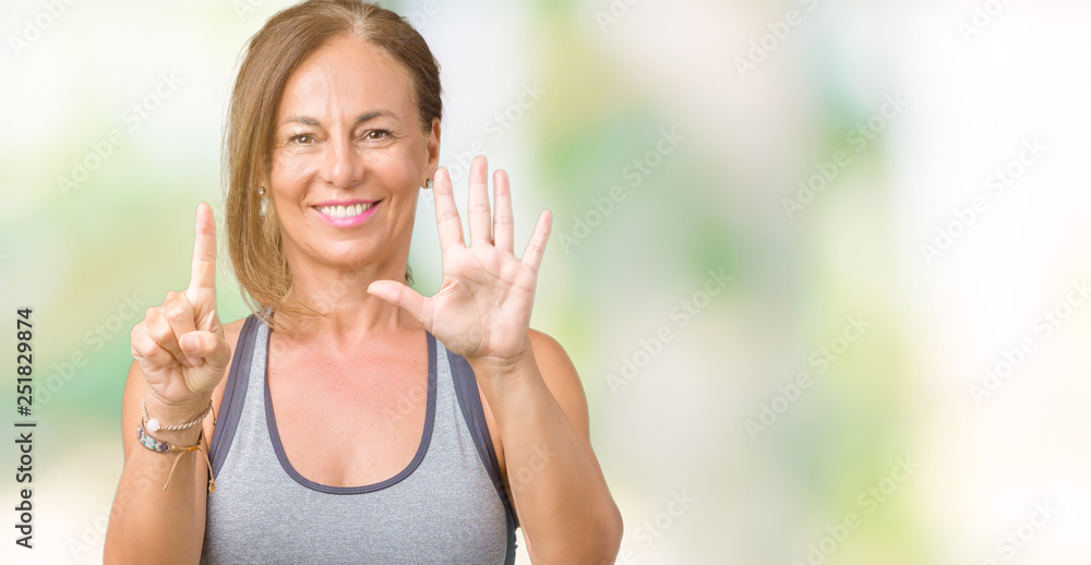 Beautiful middle age woman wearing sport clothes over isolated background showing and pointing up with fingers number six while smiling confident and happy.