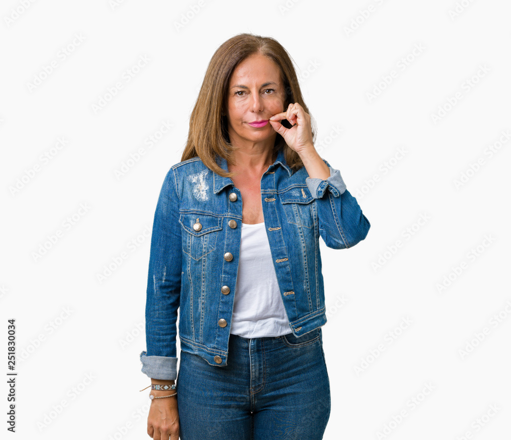Beautiful middle age woman wearing casual denim jacket over isolated background mouth and lips shut as zip with fingers. Secret and silent, taboo talking Beautiful middle age woman wearing casual denim jacket over isolated background mouth and lips shut as zip with fingers. Secret and silent, taboo talking