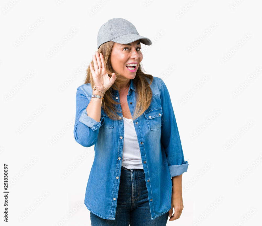 Beautiful middle age woman wearing sport cap over isolated background smiling with hand over ear listening an hearing to rumor or gossip. Deafness concept. Beautiful middle age woman wearing sport cap over isolated background smiling with hand over ear listening an hearing to rumor or gossip. Deafness concept.
