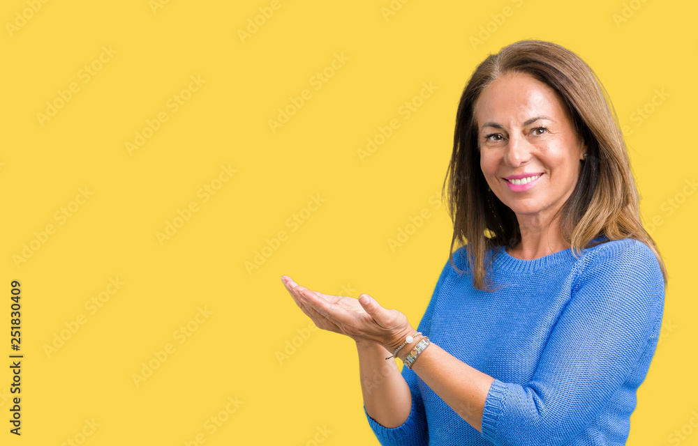 Middle age beautiful woman wearing winter sweater over isolated background Pointing to the side with hand and open palm, presenting ad smiling happy and confident Middle age beautiful woman wearing winter sweater over isolated background Pointing to the side with hand and open palm, presenting ad smiling happy and confident