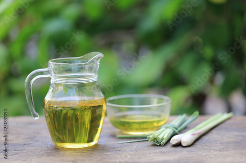 Lemongrass essential oil in glass bottles on natural green background