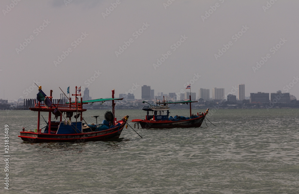 Thai wooden fishing boats at anchor near the shore
