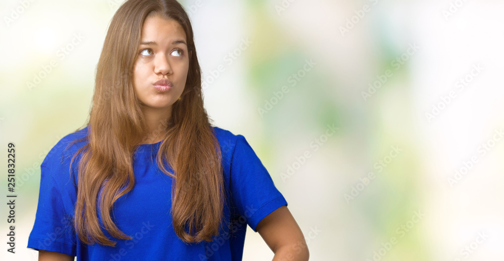 Young beautiful brunette woman wearing blue t-shirt over isolated background making fish face with lips, crazy and comical gesture. Funny expression. Young beautiful brunette woman wearing blue t-shirt over isolated background making fish face with lips, crazy and comical gesture. Funny expression.