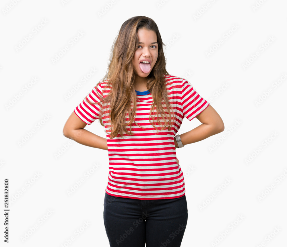 Fototapeta premium Young beautiful brunette woman wearing stripes t-shirt over isolated background sticking tongue out happy with funny expression. Emotion concept.