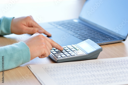 Businesswoman accounting with calculator at office