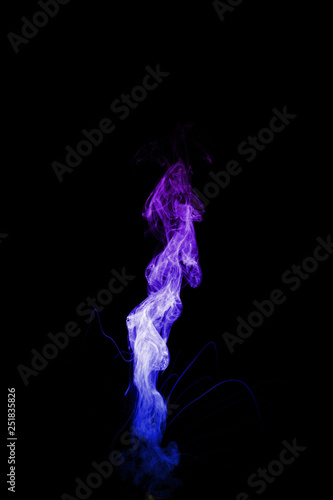 Dual colour vape steam column with spray boiling liquid. Blue and purple colour smoke. Stock photo isolated on black background.