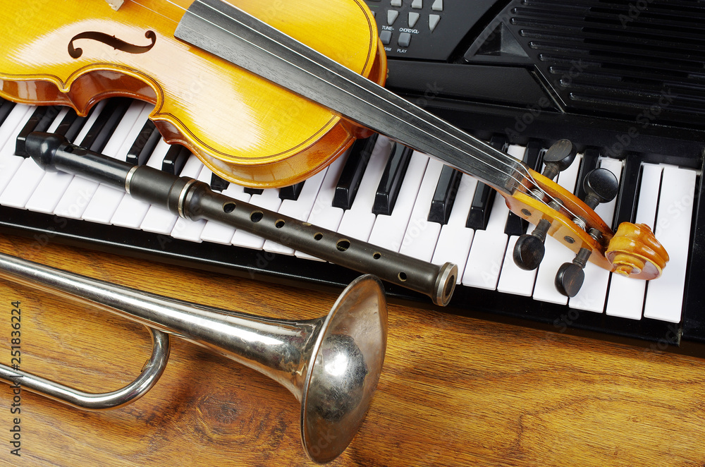 Violin, flute and trumpet on piano keyboard. Photos | Adobe Stock