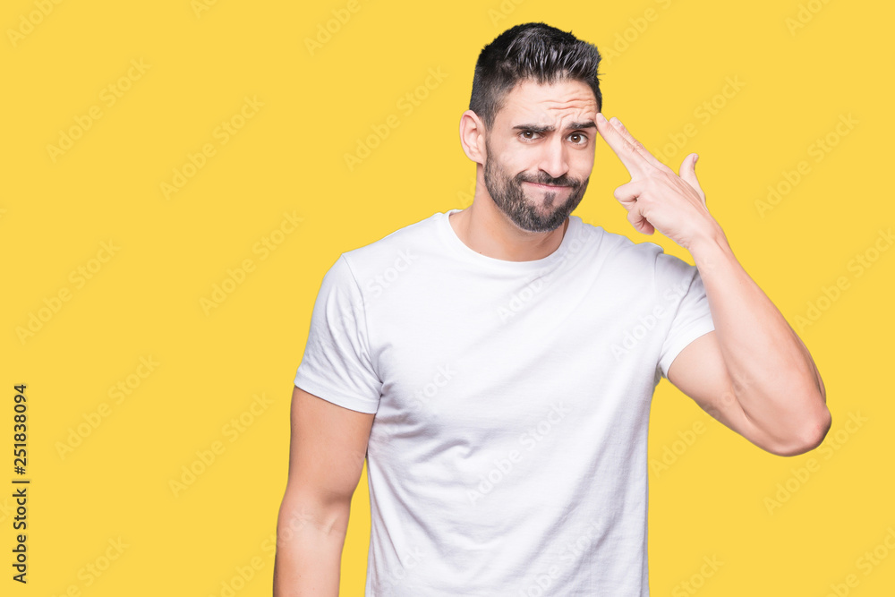 Handsome man wearing white t-shirt over yellow isolated background Shooting and killing oneself pointing hand and fingers to head, suicide gesture. Handsome man wearing white t-shirt over yellow isolated background Shooting and killing oneself pointing hand and fingers to head, suicide gesture.
