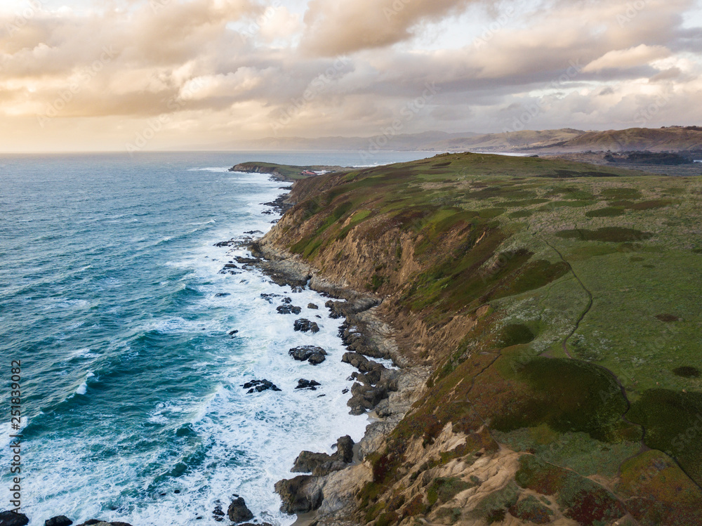 Aerial view of waves crashing along the rocky California coast near San Francisco.