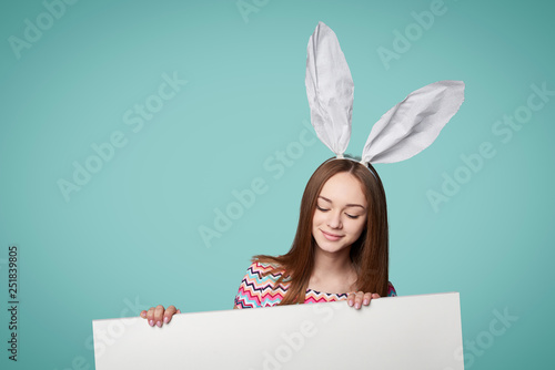 Girl wearing bunny ears holding a banner photo