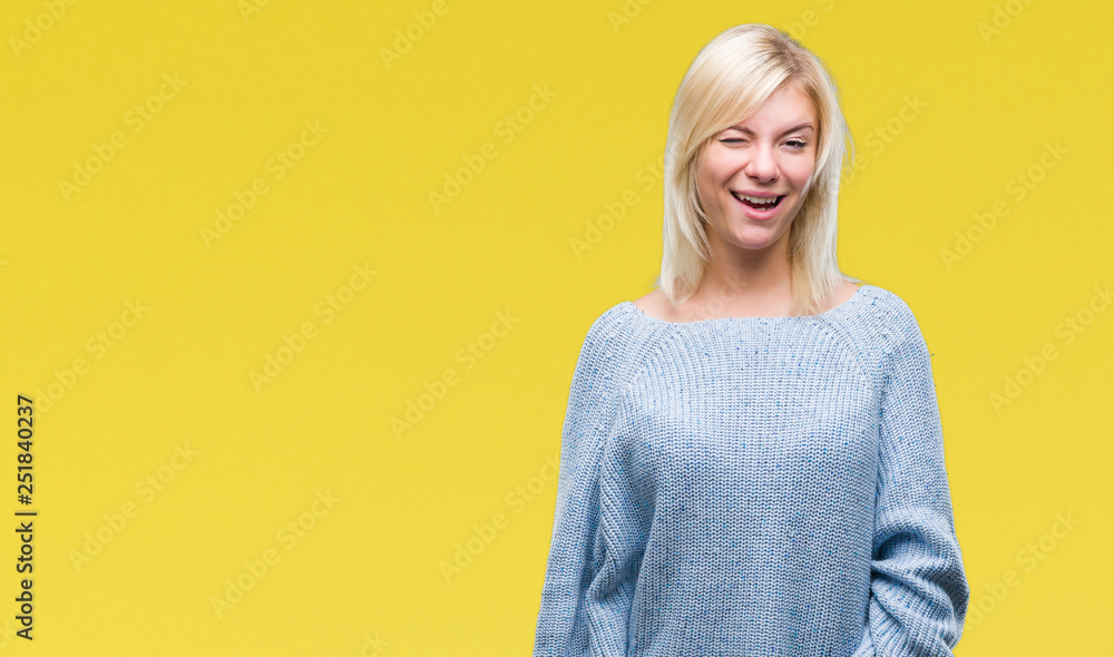 Young beautiful blonde woman wearing winter sweater over isolated background winking looking at the camera with sexy expression, cheerful and happy face. Young beautiful blonde woman wearing winter sweater over isolated background winking looking at the camera with sexy expression, cheerful and happy face.