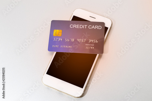 credit card put on mobile phone for preparing to pay online shopping with flare
