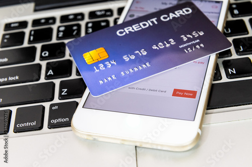 credit card put on mobile phone and laptop keyboard for preparing to pay online shopping
