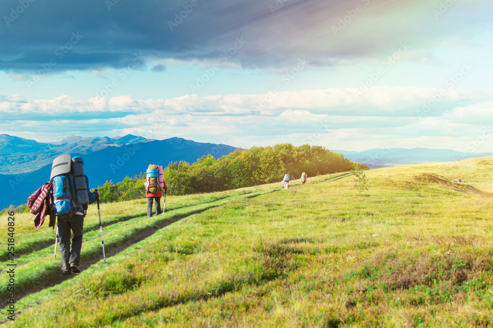 A woman with a backpack in a hike in the mountains.