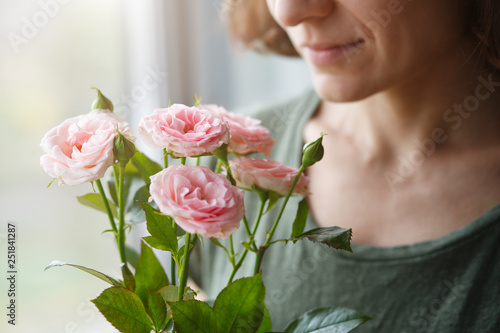 cute young woman smelling pink roses