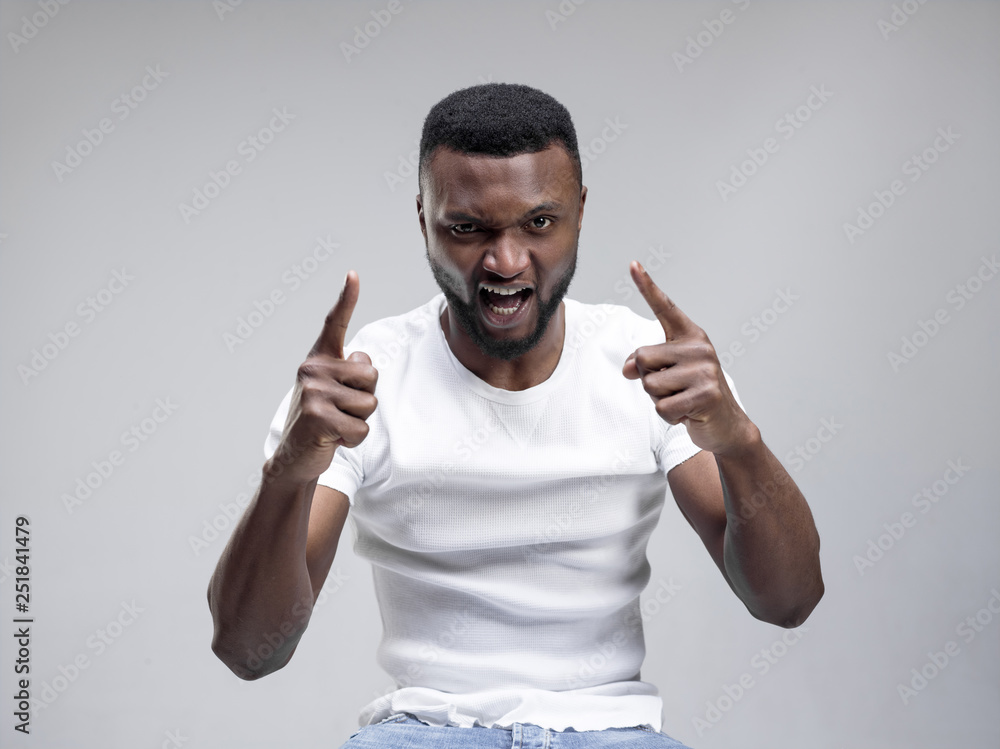 Screaming, hate, rage. Crying emotional angry african man screaming on gray studio background. Emotional, young face. male half-length portrait. Human emotions, facial expression concept. Screaming, hate, rage. Crying emotional angry african man screaming on gray studio background. Emotional, young face. male half-length portrait. Human emotions, facial expression concept.