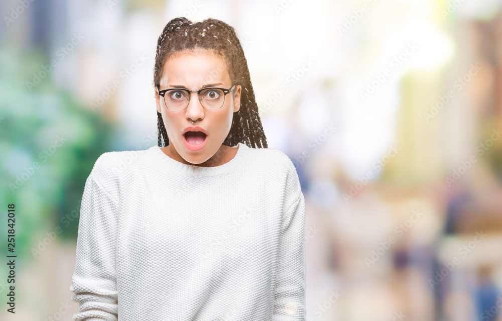 Young braided hair african american girl wearing glasses and sweater over isolated background afraid and shocked with surprise expression, fear and excited face. Young braided hair african american girl wearing glasses and sweater over isolated background afraid and shocked with surprise expression, fear and excited face.