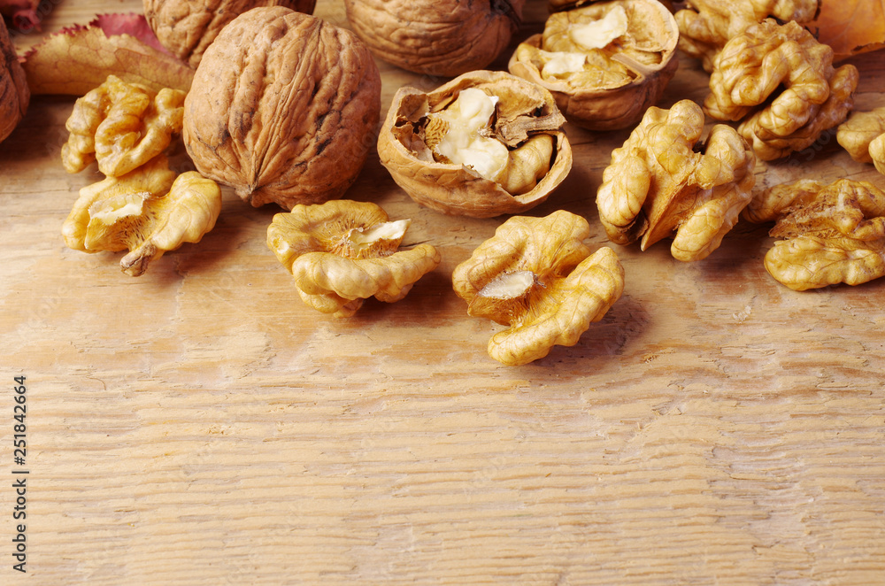 Inshell walnuts and walnut kernels on a wooden table Inshell walnuts and walnut kernels on a wooden table