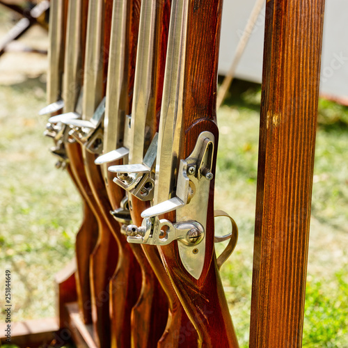 Ancient flint-guns stand in a row photo