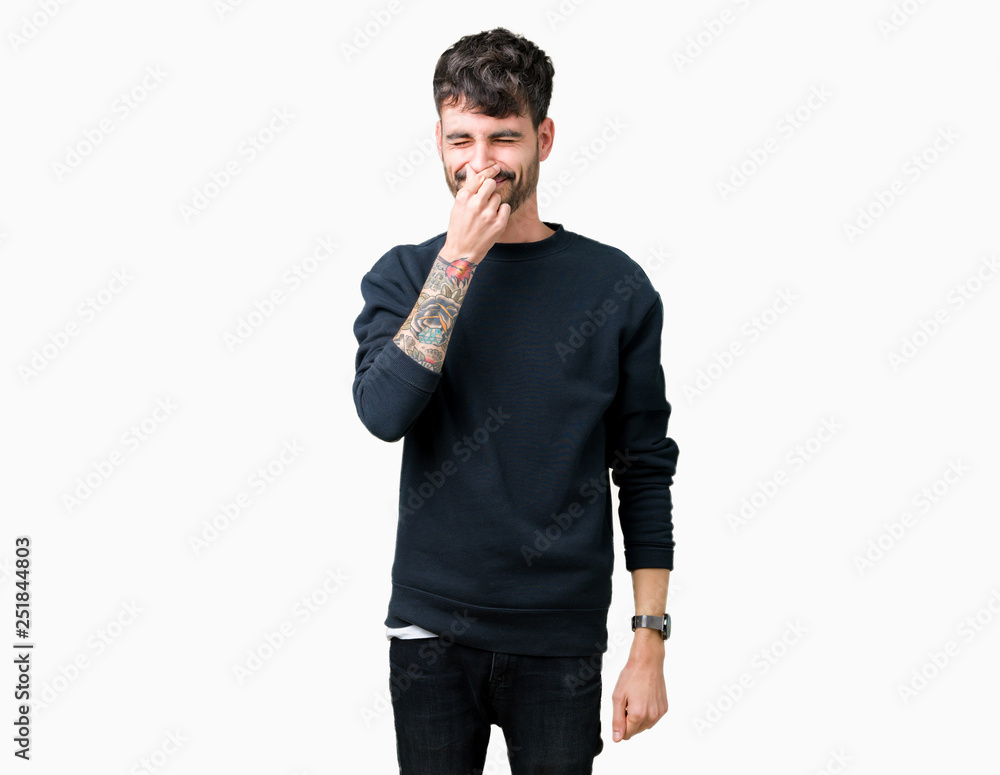 Young handsome man over isolated background smelling something stinky and disgusting, intolerable smell, holding breath with fingers on nose. Bad smells concept. Young handsome man over isolated background smelling something stinky and disgusting, intolerable smell, holding breath with fingers on nose. Bad smells concept.