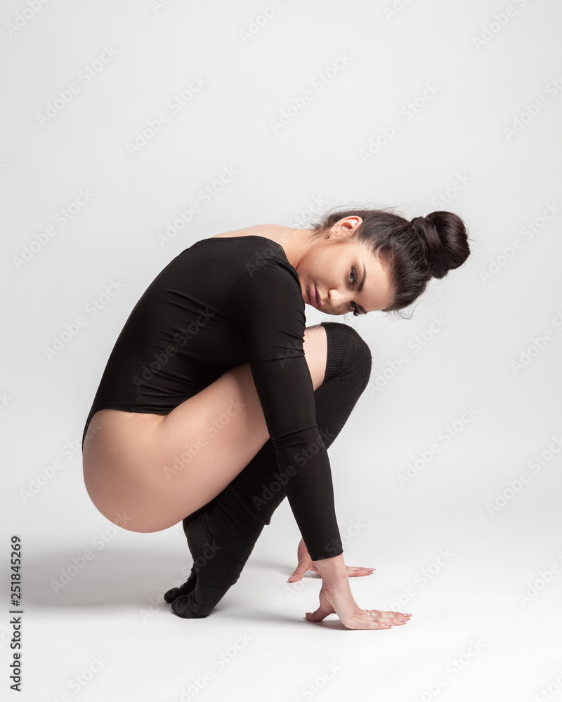beautiful brunette in a black body on a gray background beautiful brunette in a black body on a gray background