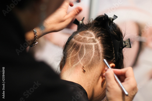 The hands of hairdresser making haircut to attractive man 