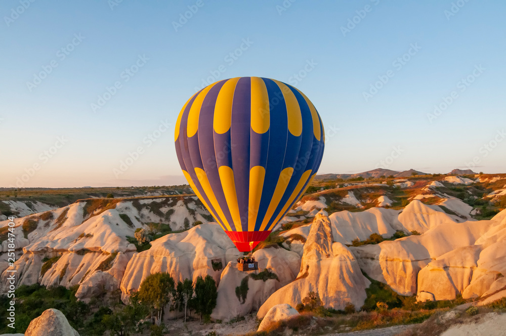 Fototapeta premium Cappadocia Turkey. Balloons at the sunrise fly over the beautiful cave.