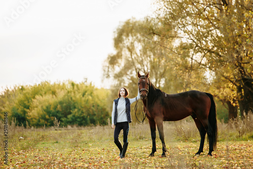 Woman with her horse at sunset, autumn outdoors scene © matilda553