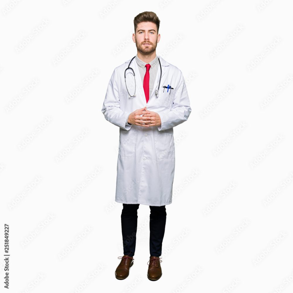 Young handsome doctor man wearing medical coat Hands together and fingers crossed smiling relaxed and cheerful. Success and optimistic Young handsome doctor man wearing medical coat Hands together and fingers crossed smiling relaxed and cheerful. Success and optimistic