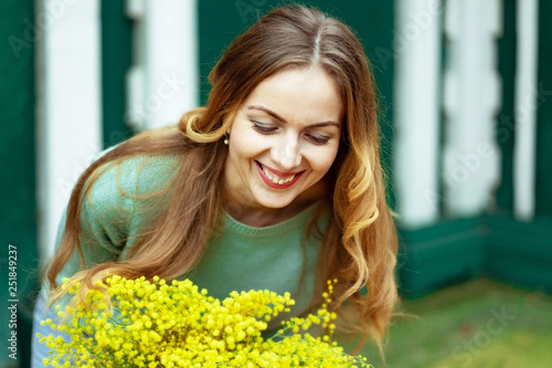 close-up woman receives flowers and rejoices and smiles at gift