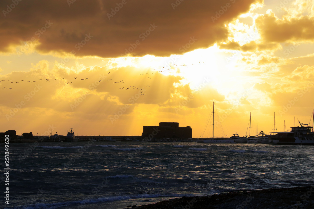 Sunset with view to Paphos Castle with big waves, Cyprus