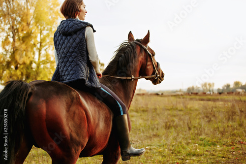 Beautiful girl riding a horse on autumn field