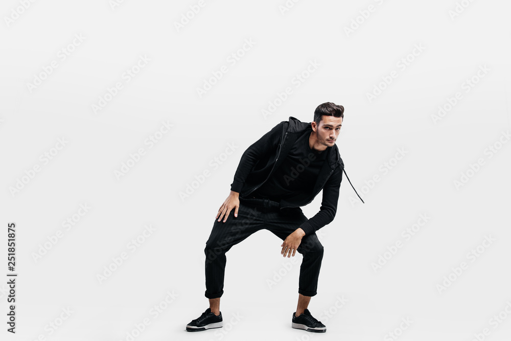 Handsome young man dressed in a sport black clothes is dancing street dance. Handsome young man dressed in a sport black clothes is dancing street dance.