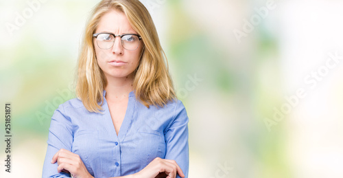 Beautiful young business woman over isolated background skeptic and nervous, disapproving expression on face with crossed arms. Negative person.