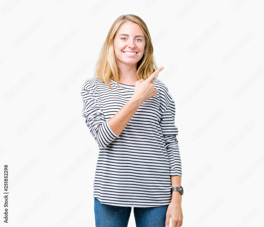 Beautiful young woman wearing stripes sweater over isolated background cheerful with a smile of face pointing with hand and finger up to the side with happy and natural expression on face Beautiful young woman wearing stripes sweater over isolated background cheerful with a smile of face pointing with hand and finger up to the side with happy and natural expression on face