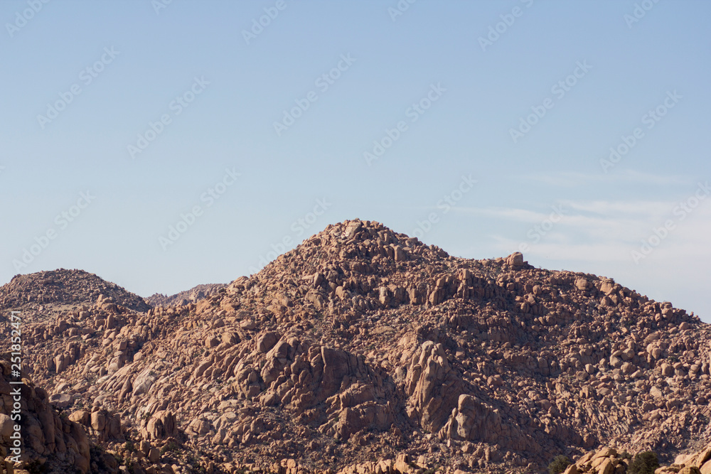 Rocky desert at day with harsh sunlight and blue sky 