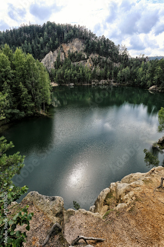 Lake under the rocky cliff with the mountain