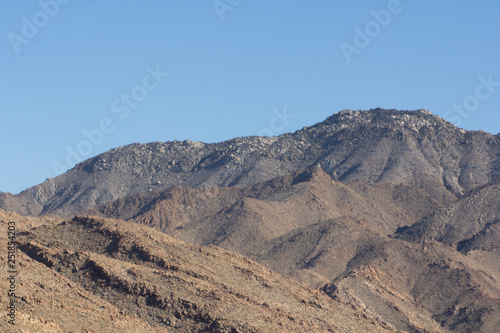 Rocky desert at day with harsh sunlight and blue sky 