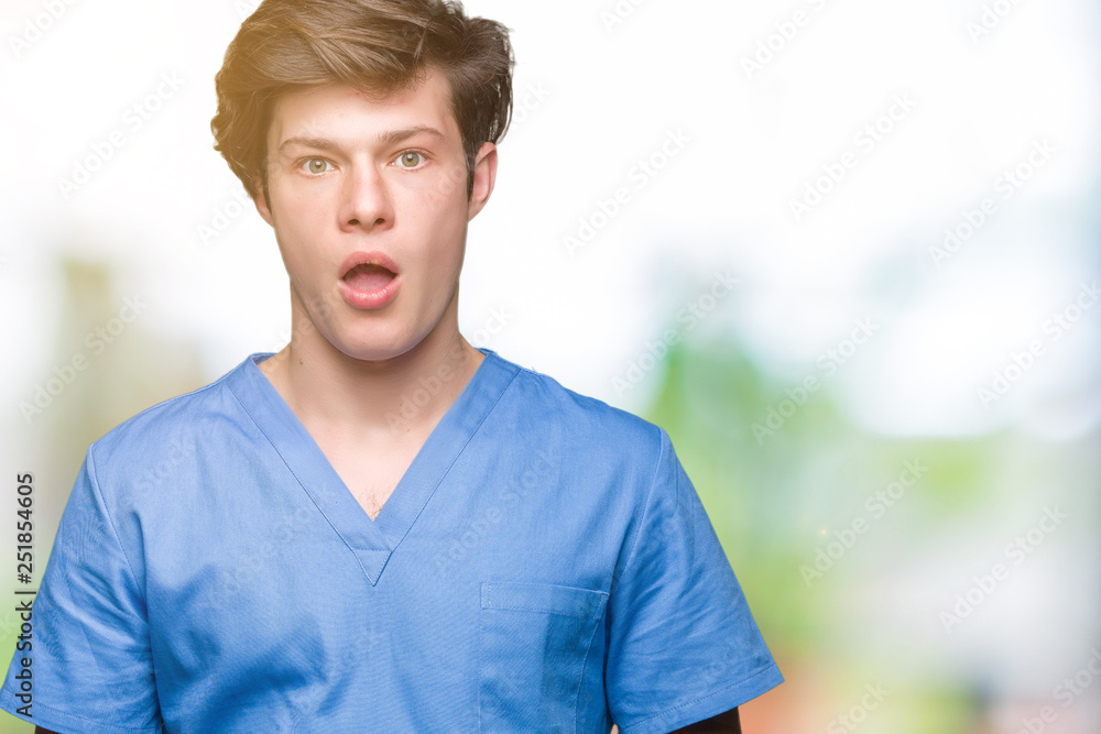 Young doctor wearing medical uniform over isolated background afraid and shocked with surprise expression, fear and excited face. Young doctor wearing medical uniform over isolated background afraid and shocked with surprise expression, fear and excited face.