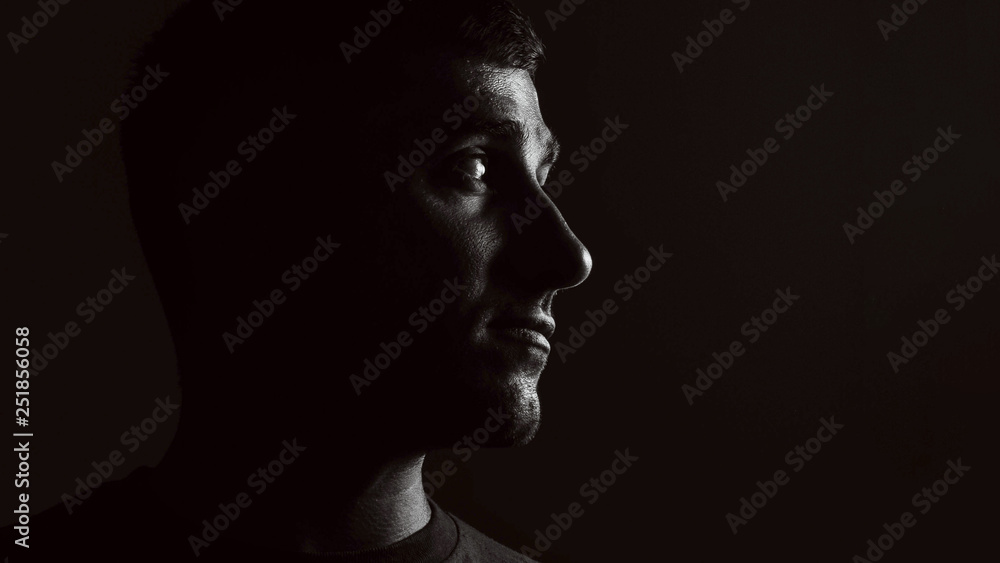 portrait of a guy on a black background in low key portrait of a guy on a black background in low key