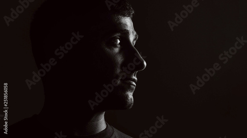 portrait of a guy on a black background in low key