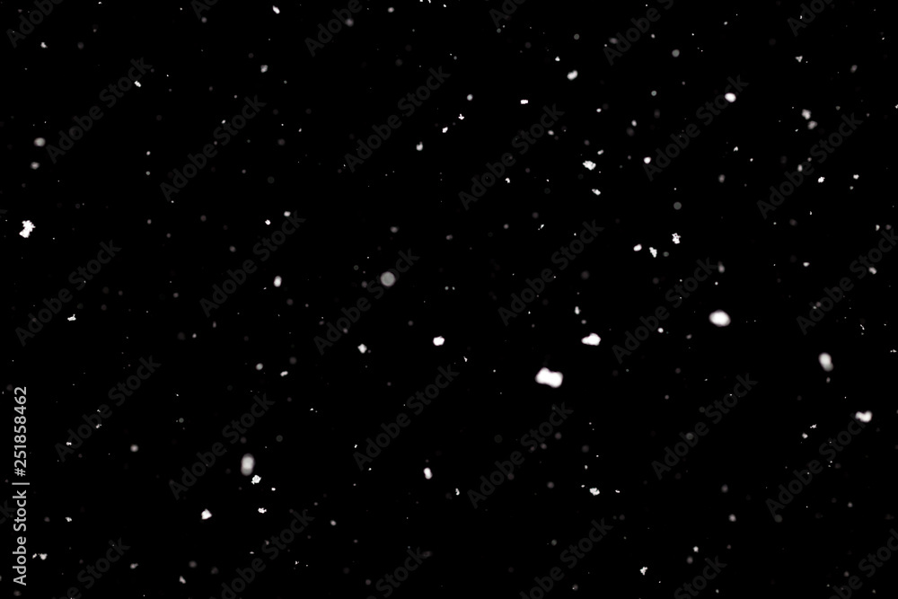 Snowstorm texture. Bokeh lights on black background, shot of flying snowflakes in the air Snowstorm texture. Bokeh lights on black background, shot of flying snowflakes in the air