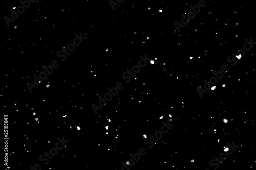 Snowstorm texture. Bokeh lights on black background  shot of flying snowflakes in the air