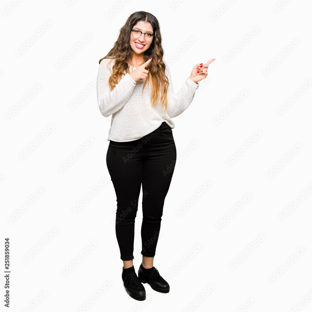 Young beautiful woman wearing glasses smiling and looking at the camera pointing with two hands and fingers to the side. Young beautiful woman wearing glasses smiling and looking at the camera pointing with two hands and fingers to the side.