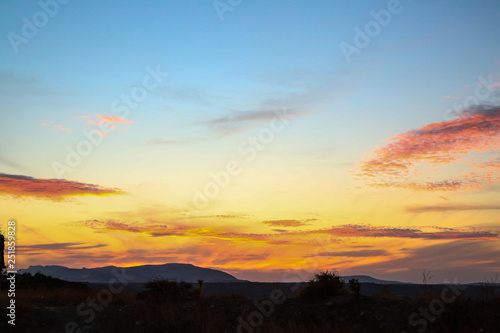 all colors colours orange red purple blue sunset sky over hilly landscape steppe © Sylvia