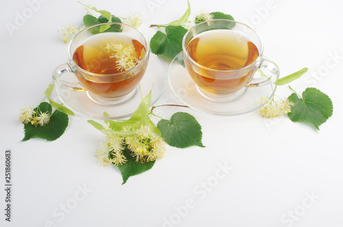   Tea with linden flowers. Two cups of tea and linden flowers and leaves