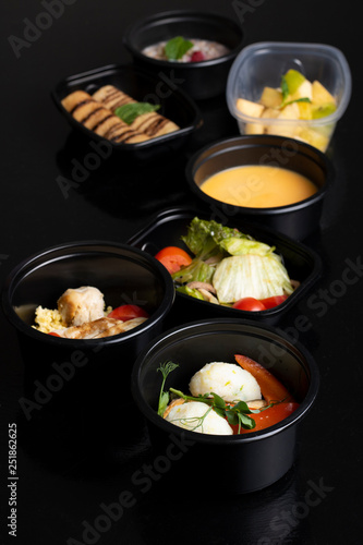 lunch boxes with porridge, salad, boiled meat and sweets
