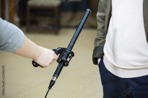 Condenser Shotgun Microphone. A woman interviews a man. The microphone in the reporter's hand.