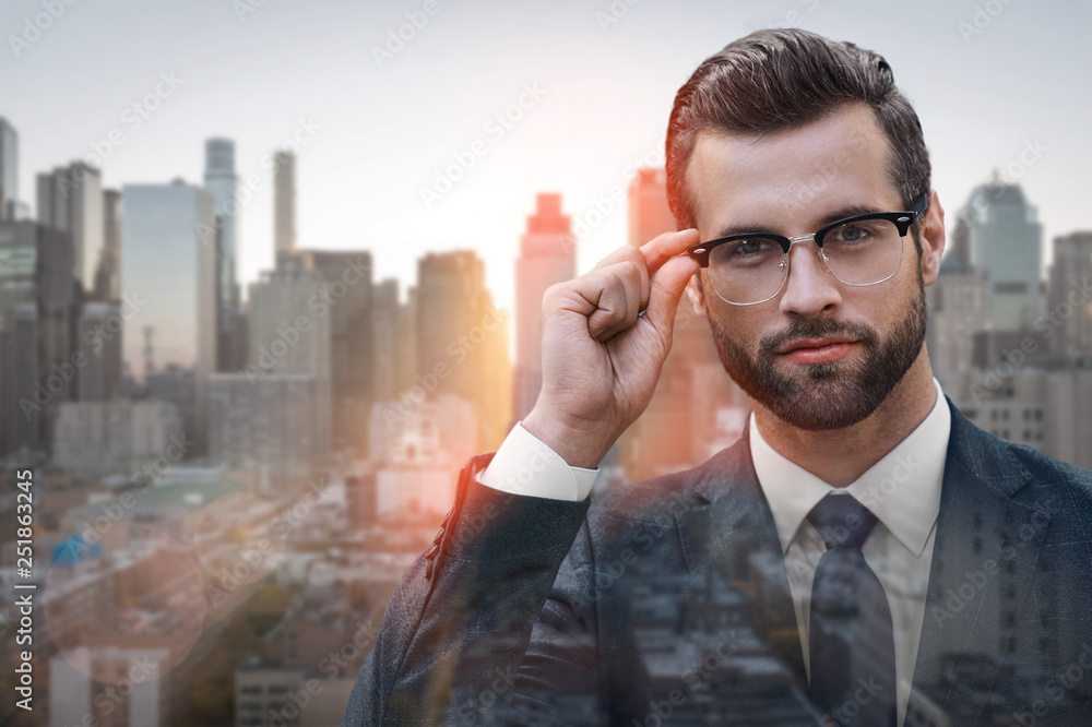 I can see this clearly. Close-up of young and successful businessman looking at camera and adjusting glasses while standing outdoors I can see this clearly. Close-up of young and successful businessman looking at camera and adjusting glasses while standing outdoors